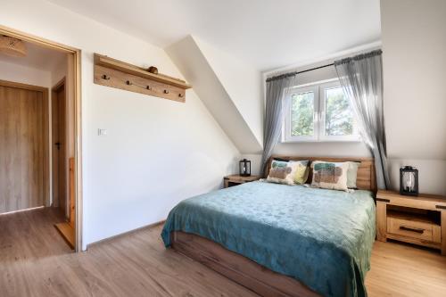 a bedroom with a bed and a window at Domek w brzozach in Chańcza