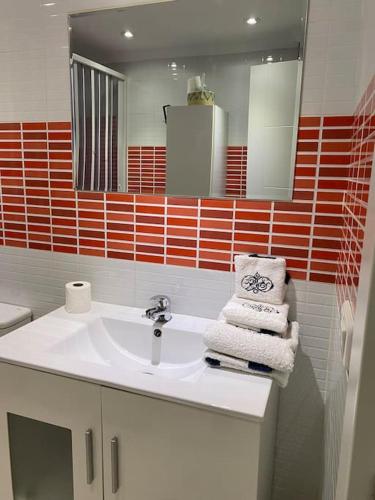 a bathroom with a sink and a mirror and towels at Apartamento SILDA in Torre del Mar