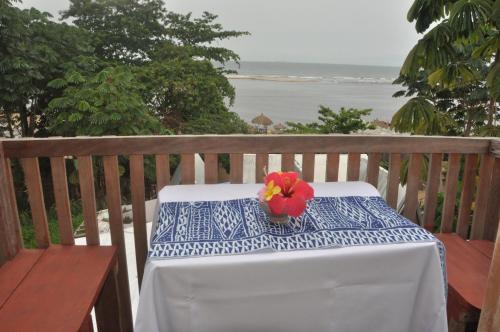 a table with a red flower on a blue and white table cloth at Kribi-Lodge in Kribi