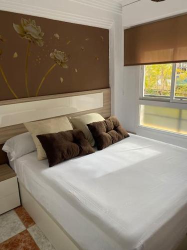 a white bed with two pillows on it in a bedroom at Apartamento SILDA in Torre del Mar