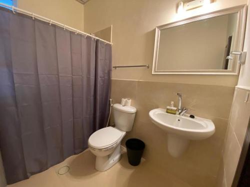 a bathroom with a toilet and a sink and a mirror at The 1st Night Hotel in Amman