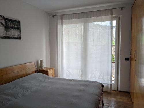- une chambre avec un lit et une porte coulissante en verre dans l'établissement La Terrazza su Trento: vista e relax, à Trente