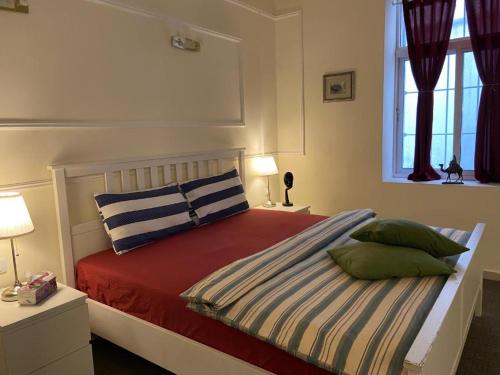 um quarto com uma cama com almofadas e uma janela em The 1st Night Hotel em Amã