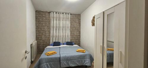 um quarto com uma cama com lençóis azuis e almofadas amarelas em NICROB em Monfalcone