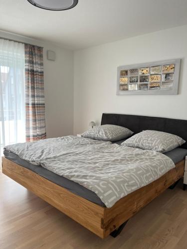ein Bett in einem Schlafzimmer mit einem Holzrahmen in der Unterkunft Ferienwohnung MiKa in Friedrichshafen