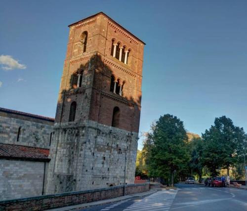a tall brick clock tower on the side of a building at Pisa Happy House in Pisa