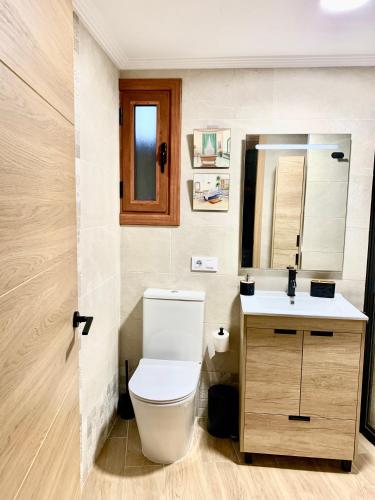 a bathroom with a toilet and a sink at Villa a pie de playa in Moaña