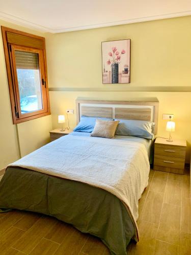 a bedroom with a large bed with two night stands at Villa a pie de playa in Moaña