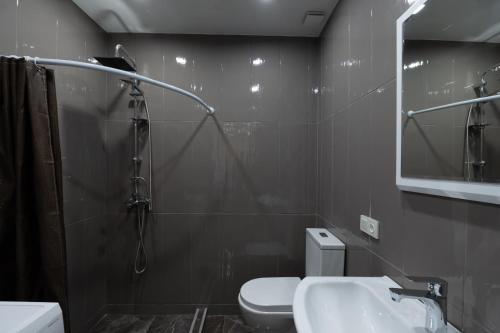 uma casa de banho com um chuveiro, um WC e um lavatório. em Apartment 45 em Tbilisi