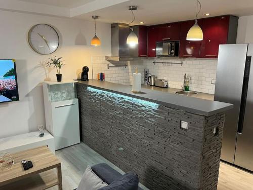uma cozinha com um balcão e uma parede de tijolos em Échappée mer LH em Le Havre