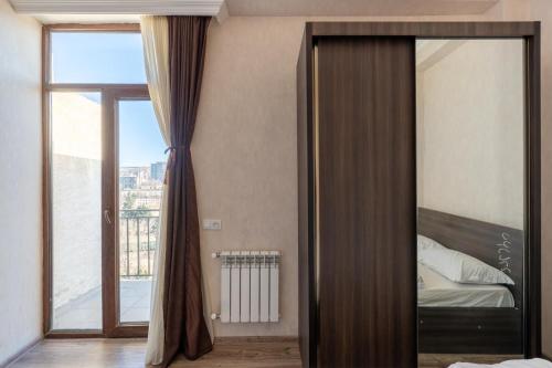 um quarto com um espelho e uma cama com uma janela em Apartment 45 em Tbilisi