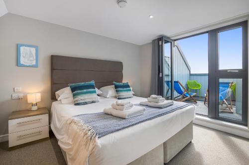 a bedroom with a large bed with towels on it at Polzeath Beach House in Polzeath