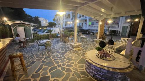a patio with a table and chairs and a building at Diaporos Hotel in Vourvourou