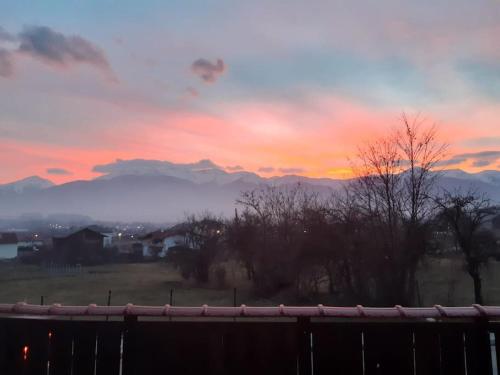 a sunset over a field with mountains in the background at Villa Detelina near the Bansko Ski Resort with Jacuzzi in Razlog