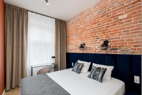 - une chambre avec un mur en briques et un lit dans l'établissement 1898 Parkside Boutique Residence, à Cracovie