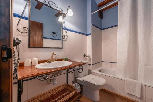 uma casa de banho com um lavatório, um WC e uma banheira em Hotel - Restaurante Prado Del Navazo em Albarracín