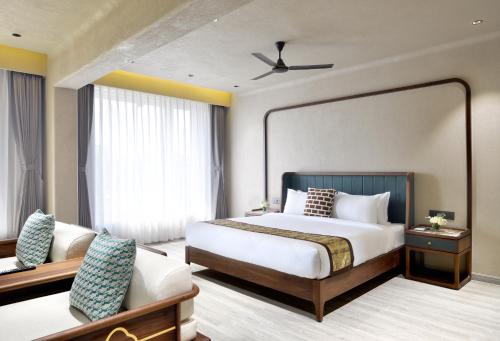a bedroom with a large bed and a couch at Urbane By Treat Daman in Daman