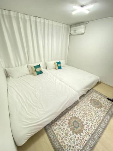 a white bed in a room with a rug at Time House - Dongdaemun district in Seoul