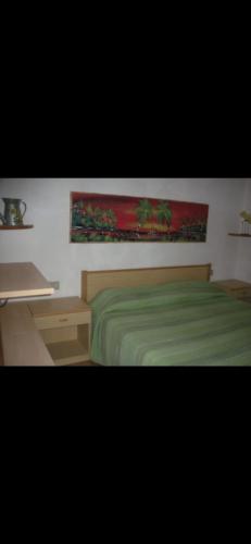 1 dormitorio con cama verde y escritorio en Villa - Torre dei Corsari-, en Torre dei Corsari