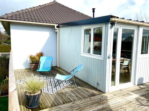 une maison avec deux chaises et une table sur une terrasse dans l'établissement Maison de plain pied proche Honfleur et Deauville, à Beuzeville