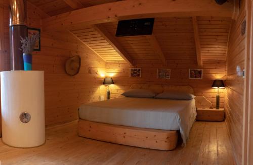 - une chambre avec un lit dans une pièce en bois dans l'établissement B&B Mappamundi, à San Benedetto Val di Sambro