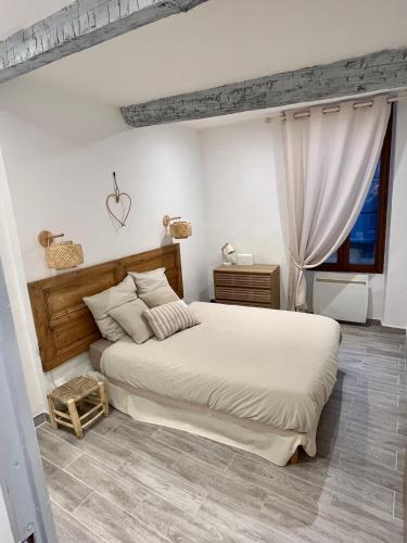 une chambre avec un grand lit et une fenêtre dans l'établissement Appartement T2 centre village, à Cucuron