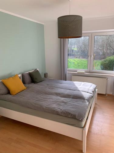 un lit dans une chambre avec une grande fenêtre dans l'établissement Sonniges Garten-Apartment in ruhiger Parklage, à Bad Segeberg