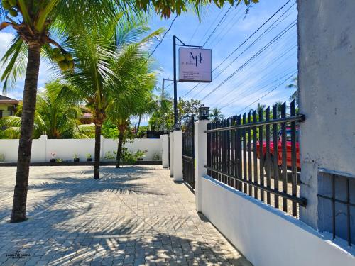 uma cerca com uma palmeira ao lado de um passeio em MP Apartments Leyte em Hindang