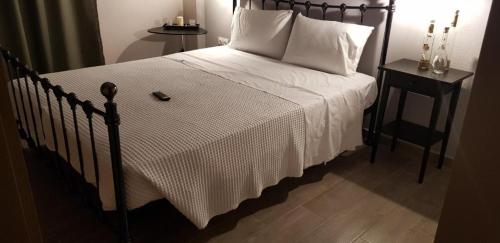 a bedroom with a bed with a white bedspread and a night stand at Villanta 2 in Kallirákhi