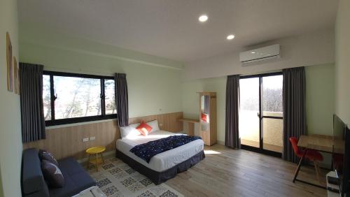 - une chambre avec un lit, un bureau et des fenêtres dans l'établissement Star Wishes B&B, à Huxi