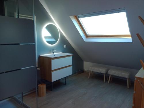 een badkamer met een wastafel en een dakraam bij DOMAINE DES TISSEYS vue sur le Mont St Michel in Dragey