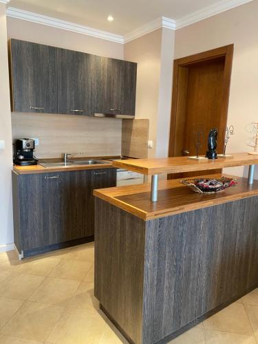 - une cuisine avec des placards en bois et un comptoir dans l'établissement AJ Apartment 1 with Pool view, Santa Marina Holiday Village, Sozopol, à Sozopol
