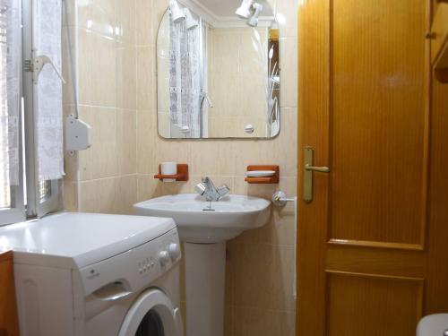 een badkamer met een wastafel en een wasmachine bij Casa Josefa in Villasuso de Cieza