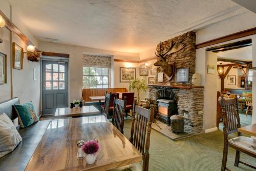 a living room with a table and a fireplace at The Crown Hotel in Exford