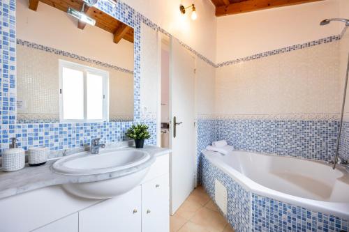 baño azul y blanco con bañera y lavamanos en AnchorHouse Portugal, en Aljezur