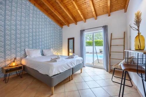 a bedroom with a bed and a large window at AnchorHouse Portugal in Aljezur