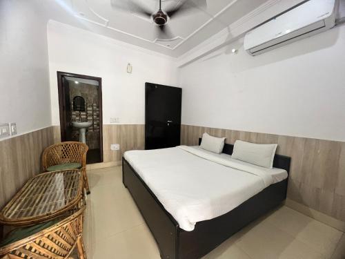 a bedroom with a bed and a chair in it at Tulsi Cottage in Rishīkesh