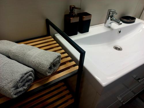a bathroom with a white sink and a towel at Apartament Pogodny in Łeba
