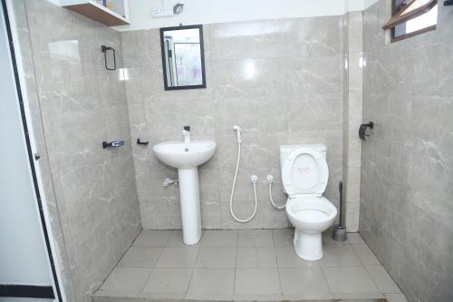 a bathroom with a toilet and a sink at Rose Fort Homestay in Jaffna
