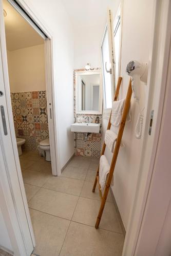 a bathroom with a toilet and a sink and a ladder at B&B - Le Tre Comari in Ragusa