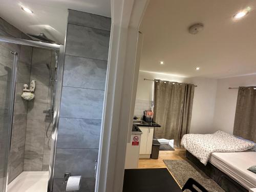 a small bathroom with a shower and a bed at 1st Studio Flat With full Private Toilet And Shower With its Own Kitchenette in Keedonwood Road Bromley A Fully Equipped Independent Studio Flat in Bromley