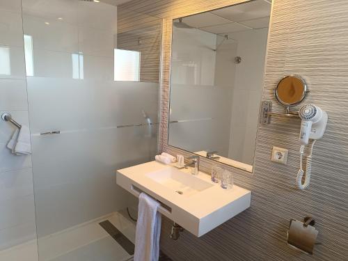 a bathroom with a sink and a mirror and a shower at Mendez Nuñez Alicante in Alicante