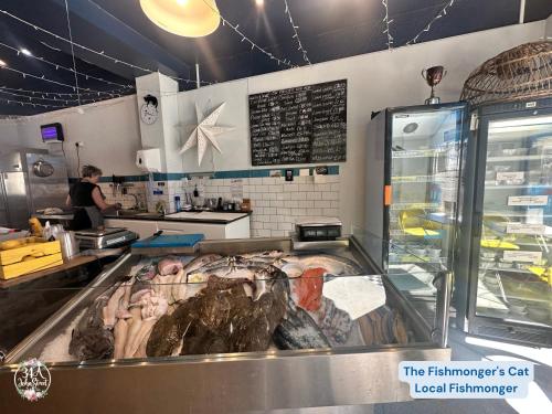 a woman standing in a restaurant kitchen with a counter at COASTAL RETREAT Town Centre Entire Property, Very Close to Sea & Restaurants, 2 King Size Beds in Porthcawl