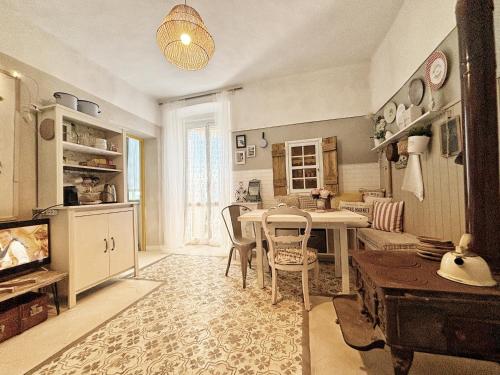 une cuisine avec une table et des chaises ainsi qu'une salle à manger dans l'établissement La casa dei nonni, à Bracelli