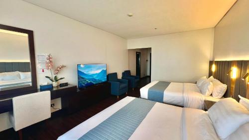 Mountain View,Room 549 Private Unit at The Forest Lodge,Camp John Hay Suites في باغيو: غرفه فندقيه سريرين وتلفزيون