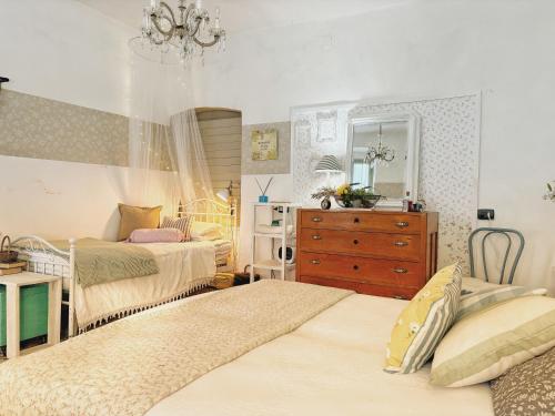 - une chambre avec 2 lits et une commode dans l'établissement La casa dei nonni, à Bracelli