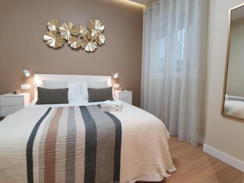 Apartamento de Lujo - A 10 minutos del centro في مدريد: غرفة نوم بسرير كبير وثريا