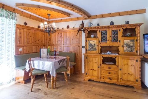 una sala da pranzo con tavolo, sedie e pareti in legno di PEISERHOF ferien.wein.gut Südsteiermark a Wies