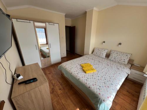 a bedroom with a bed with a yellow towel on it at VV Apartment Bansko in Bansko