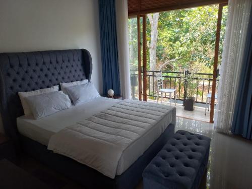 ein Schlafzimmer mit einem großen Bett und einem Fenster in der Unterkunft Gampaha Heritage in Gampaha